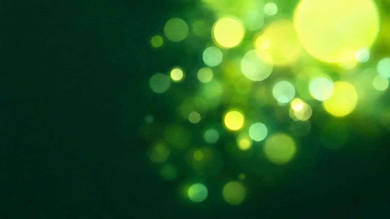 Large soft out-of-focus circles of lime and yellow light on a dark emerald background on the right, plain dark emerald on the left.